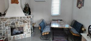 uma sala de estar com uma mesa e uma lareira em Вила Мони-зона релакс 