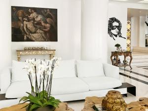 a white living room with a white couch at Grecotel Pallas Athena in Athens