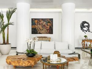 a living room with a white couch and a table at Grecotel Pallas Athena in Athens