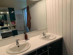 La salle de bains est pourvue de 2 lavabos et d'un grand miroir. dans l'établissement Villa de 3 chambres avec piscine chauffée, à Villette-dʼAnthon