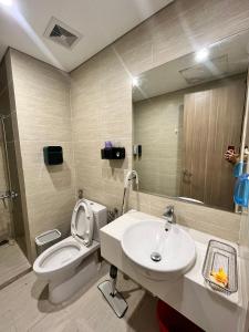 y baño con aseo, lavabo y espejo. en Skyhome en Gia Lâm Pho