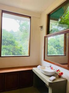 a bathroom with a sink and two large windows at Rock n Fall Nature Resort in Ella