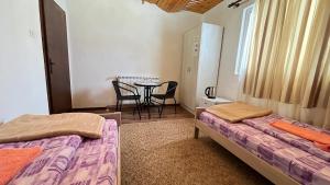 2 Betten in einem Zimmer mit Tisch und Stühlen in der Unterkunft SNAM Rooms&Apartment in Žabljak