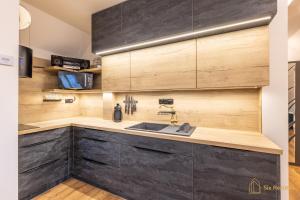 a kitchen with wooden cabinets and a sink at Apt. Plešivec in Abertamy
