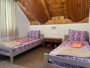 毛茛的住宿－SNAM Rooms&Apartment，配有木天花板的客房设有两张床。