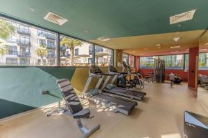 einen Fitnessraum mit Laufbändern und Kardiogeräten in einem Gebäude in der Unterkunft Cozy Studio in Beverly Residence, JVC by Suiteable in Dubai