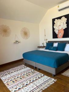a bedroom with a blue bed and a rug at Le Shelby Samui Beach Resort Cottage in Koh Samui