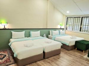 two beds in a room with two tables at Stewart Hotel at 67 By EVR - Newly Renovated 2024 in George Town