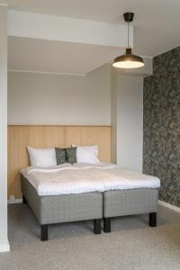 1 dormitorio con 1 cama grande con sábanas blancas en Hangon Asema 5 - yksiö terassilla, ei yhtään porrasta, en Hanko