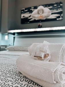 a pile of towels on a bed with a piano at Scabi Apartments in Trapani