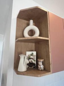 a wooden shelf with vases and a vase on it at 'NEL' - Rye Beach Studio Retreat in Rye