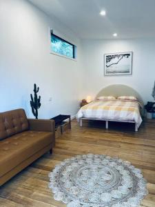 1 dormitorio con cama, sofá y alfombra en 'NEL' - Rye Beach Studio Retreat, en Rye