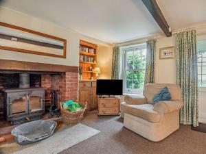 a living room with a fireplace and a chair and a television at 2 Bed in Salthouse NCC15 in Salthouse