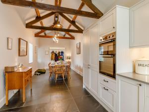 une cuisine avec des placards blancs et une salle à manger avec une table dans l'établissement 4 Bed in Exmoor 64340, à Challacombe