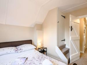 a small bedroom with a bed and a staircase at 2 Bed in Holt 73518 in Holt