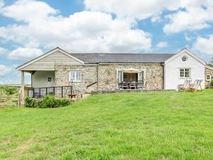 une maison en pierre avec une grande pelouse dans l'établissement 4 Bed in Exmoor 64340, à Challacombe