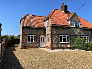 a brick house with a red roof at 2 Bed in Holt 73518 in Holt