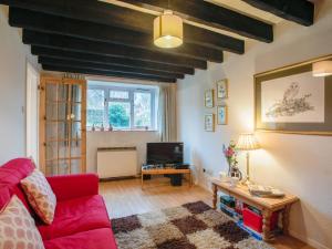 sala de estar con sofá rojo y TV en 2 Bed in Kelling NCC25, en Kelling