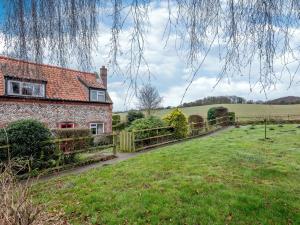 a brick house with a fence and a grass field at 2 Bed in Kelling NCC25 in Kelling