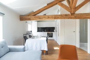a kitchen and living room with a table and chairs at Make My Day, Champagne au Mont d'or in Champagne-au-Mont-dʼOr