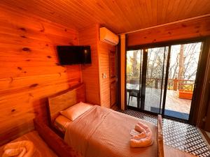 a room with a bed in a wooden cabin at Falez Cafe&Restaurant&Pansiyon-Arhavi in Arhavi