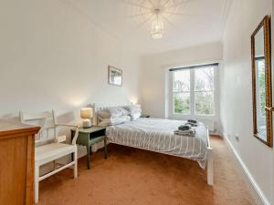 a bedroom with a bed and a desk and a window at 3 Bed in Tenby 73606 in Tenby