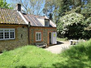 a small brick building with a bench and a table at 1 Bed in Saxlingham NCC52 in Saxlingham