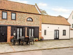 a brick house with a table and chairs on a patio at 2 Bed in Holt NCC41 in Holt