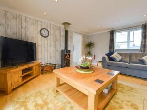 a living room with a television and a table at Lilys Pad in Okehampton