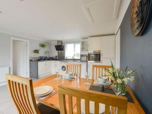 a kitchen and dining room with a wooden table and chairs at Lilys Pad in Okehampton