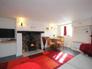 a living room with a fireplace and a table with chairs at 1 Bed in Burton Bradstock DC016 in Burton Bradstock