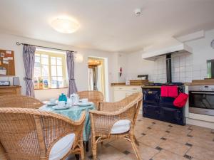 een keuken met een tafel met stoelen en een fornuis bij 3 Bed in Lulworth Cove DC023 in West Lulworth