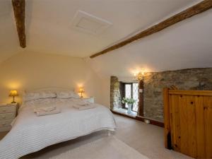 1 dormitorio con 1 cama grande y pared de piedra en 1 Bed in Weymouth DC078, en Preston