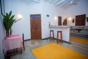 a room with a table and two stools and a door at THE CHILLI STUDIO APARTMENT in Unawatuna