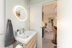 uma casa de banho branca com um lavatório e um espelho em Apartma LeMa em Velike Lašče
