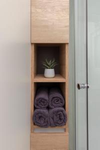 um toalheiro de madeira com toalhas e uma planta em Apartma LeMa em Velike Lašče