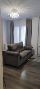 un sofá en una sala de estar con una lámpara de araña en Apartamentos CRISPIN UAT01606, en Corella