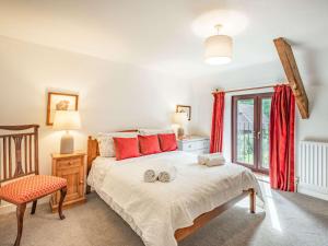 Winfrith Newburghにある3 Bed in Winfrith Newburgh DC108のベッドルーム1室(赤い枕と椅子付きのベッド1台付)