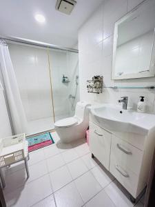 Un baño blanco con inodoro y lavabo. en Country Style Anping Homestay, en Tainan