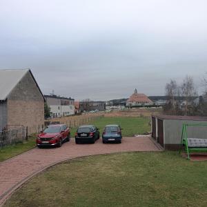 3 voitures garées dans une allée à côté d'une maison dans l'établissement Noclegi w Bilczy 5 km do Kielc, à Bilcza