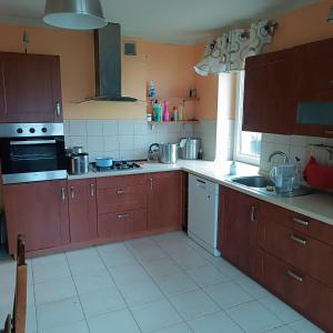 a kitchen with brown cabinets and white tile floors at Noclegi w Bilczy 5 km do Kielc in Bilcza