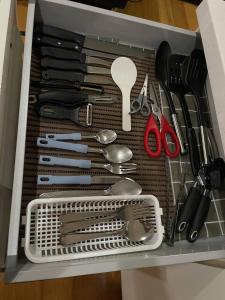 a drawer filled with lots of kitchen utensils at Homey 1BR Acqua Livingstone with Netflix, Pool & Gym in Manila