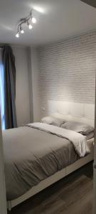1 dormitorio con 1 cama grande y pared de ladrillo en Apartamentos CRISPIN UAT01606, en Corella
