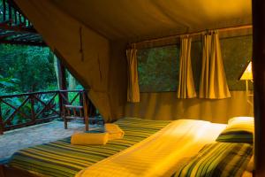 - une chambre avec un lit dans une tente dans l'établissement Kibale Forest Camp by NATURE LODGES LTD, à Kyenjojo