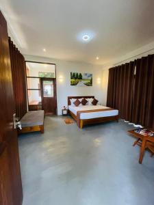 a large bedroom with a bed and a table at Rock n Fall Nature Resort in Ella