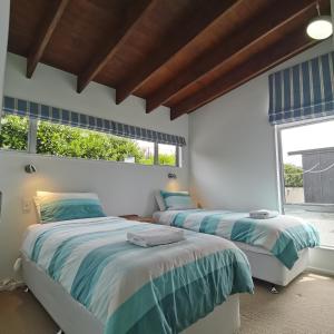 2 camas en una habitación con 2 ventanas en Three Rivers 2 Bedroom Cottage en Lake Tekapo