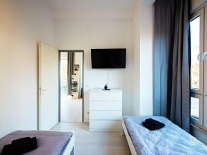 a bedroom with two beds and a flat screen tv at Work & Stay in Ahrensburg bei Hamburg in Ahrensburg