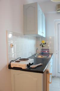 a kitchen with a toaster on a counter next to a sink at Calypso Studios in Amoudi