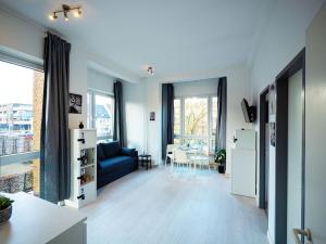 a living room with a blue couch and a table at Work & Stay in Ahrensburg bei Hamburg in Ahrensburg