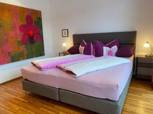 ein Schlafzimmer mit einem großen Bett mit lila Kissen in der Unterkunft Haus Wieser in Sankt Gallenkirch